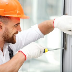 Attractive,Young,Builder,Is,Installing,Lock,In,Door.,He,Is